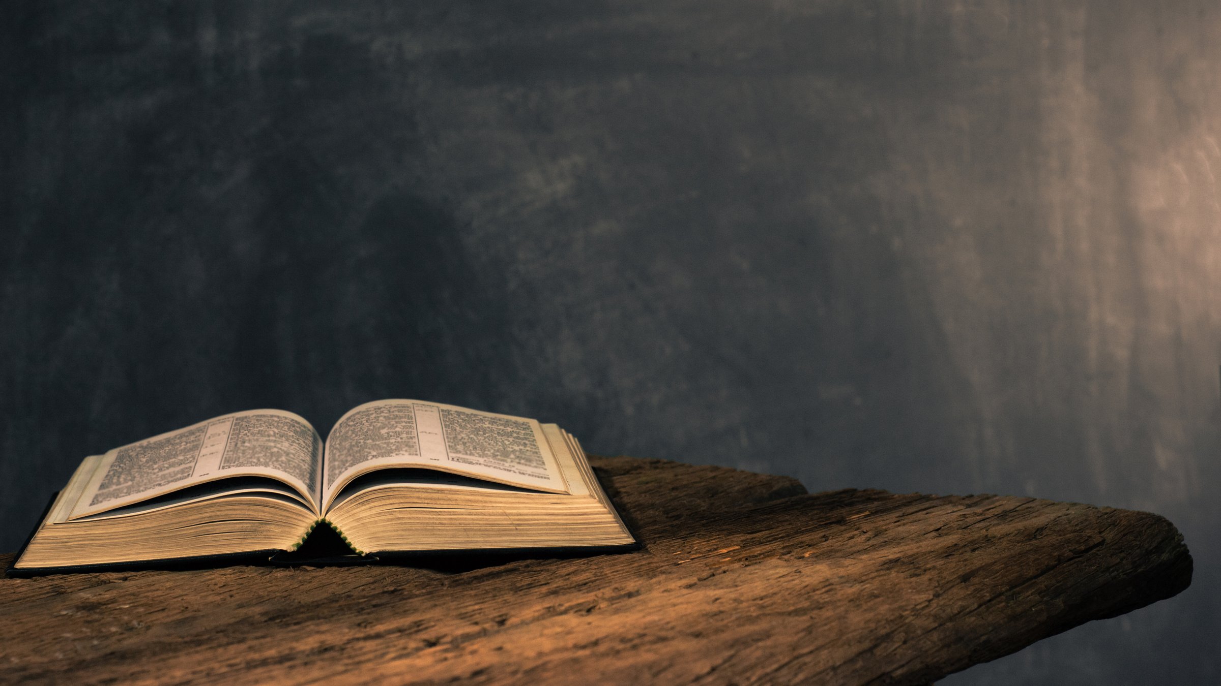 Bible on a old oak wooden table. Beautiful dark background.Religion concept